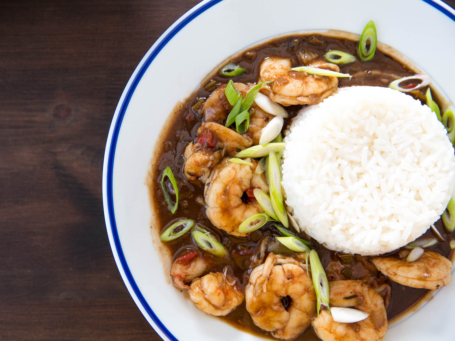 Beauty shot of shrimp etouffee, made with a dark brown roux, on the plate with rice